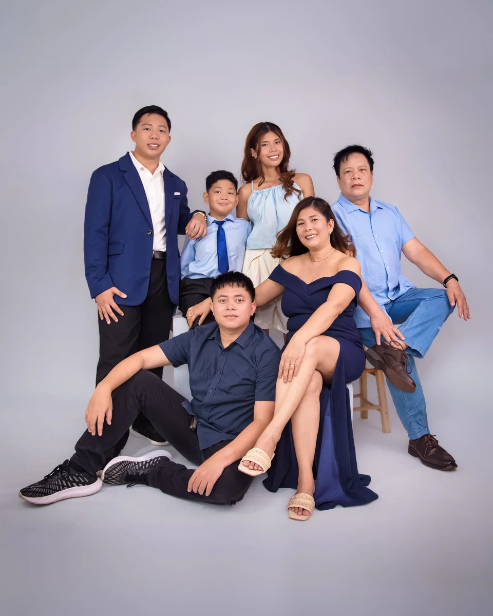 Full-length portrait of the six family members together in blue outfits.
